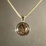 Medaillon aus massivem Gold mit einer Haarsträhne Ihres Tieres. Edle 333 Gelbgold-Fassung mit dekorativer Schmuckschlaufe